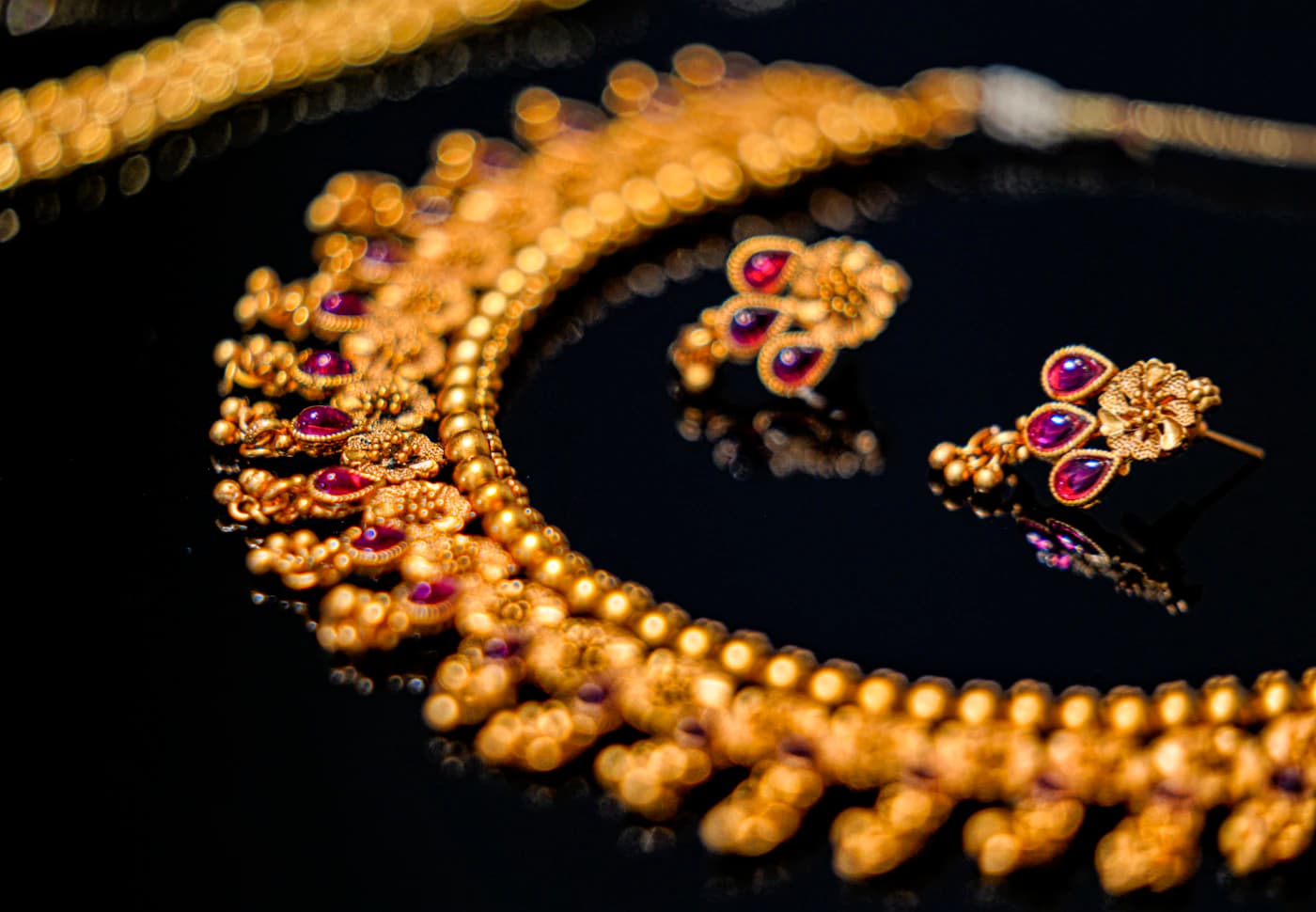 Gold necklace and earring set with ruby-toned stones