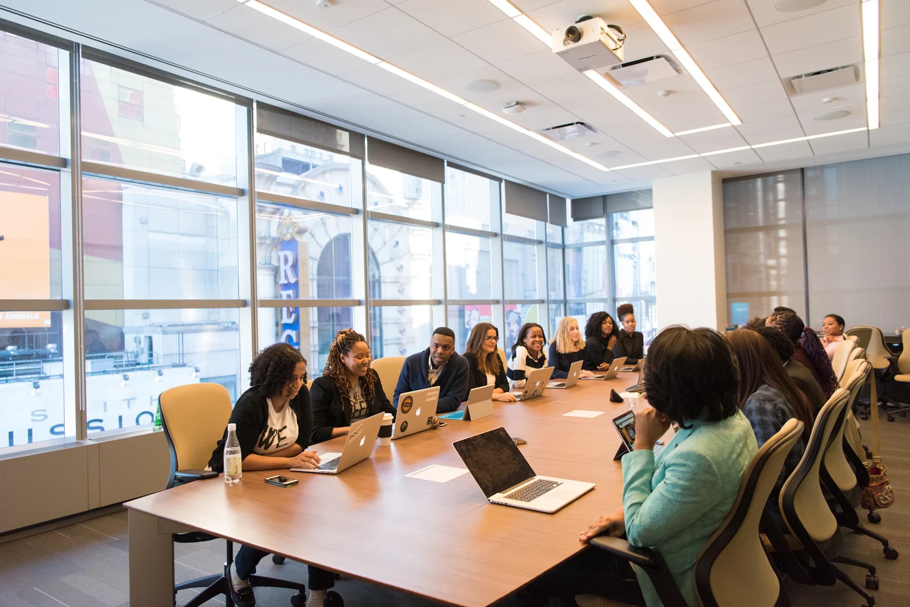 Investment team meeting around a table with laptops