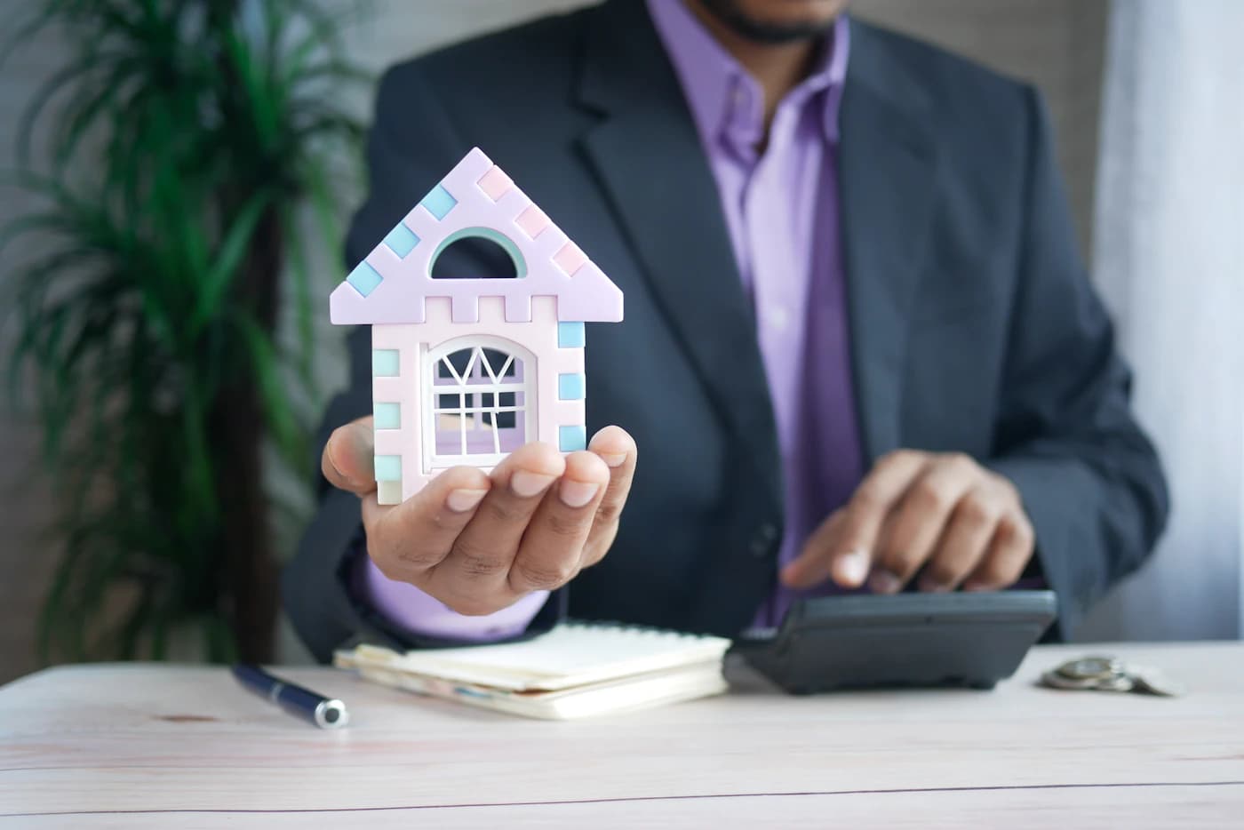 Advisor holding a small house model while reviewing figures