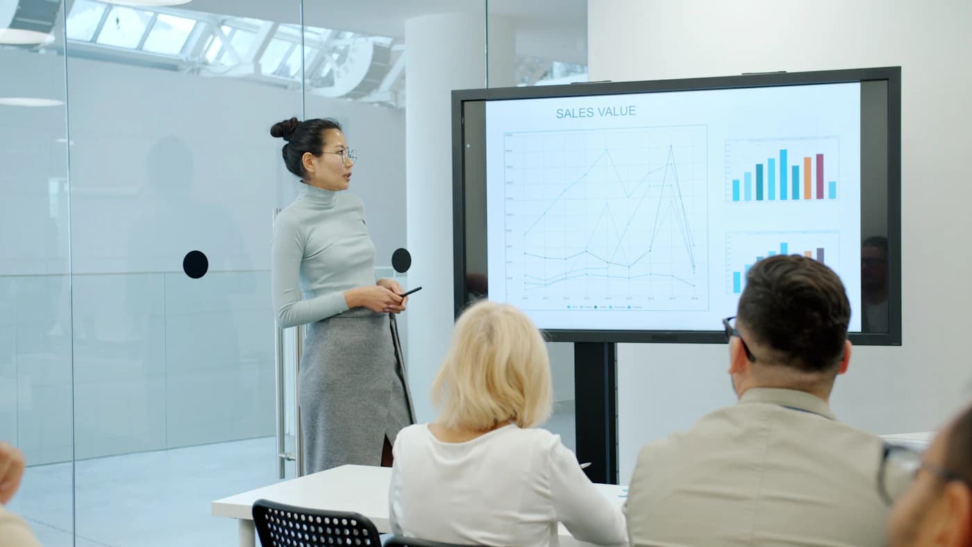 Analyst presenting a bar chart to a seated audience