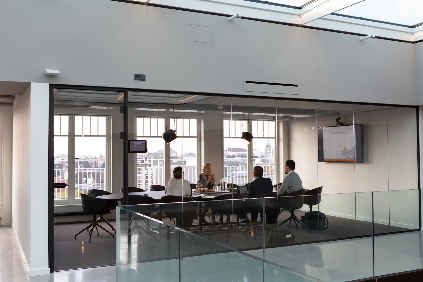 Analysts in a glass-walled meeting room reviewing research
