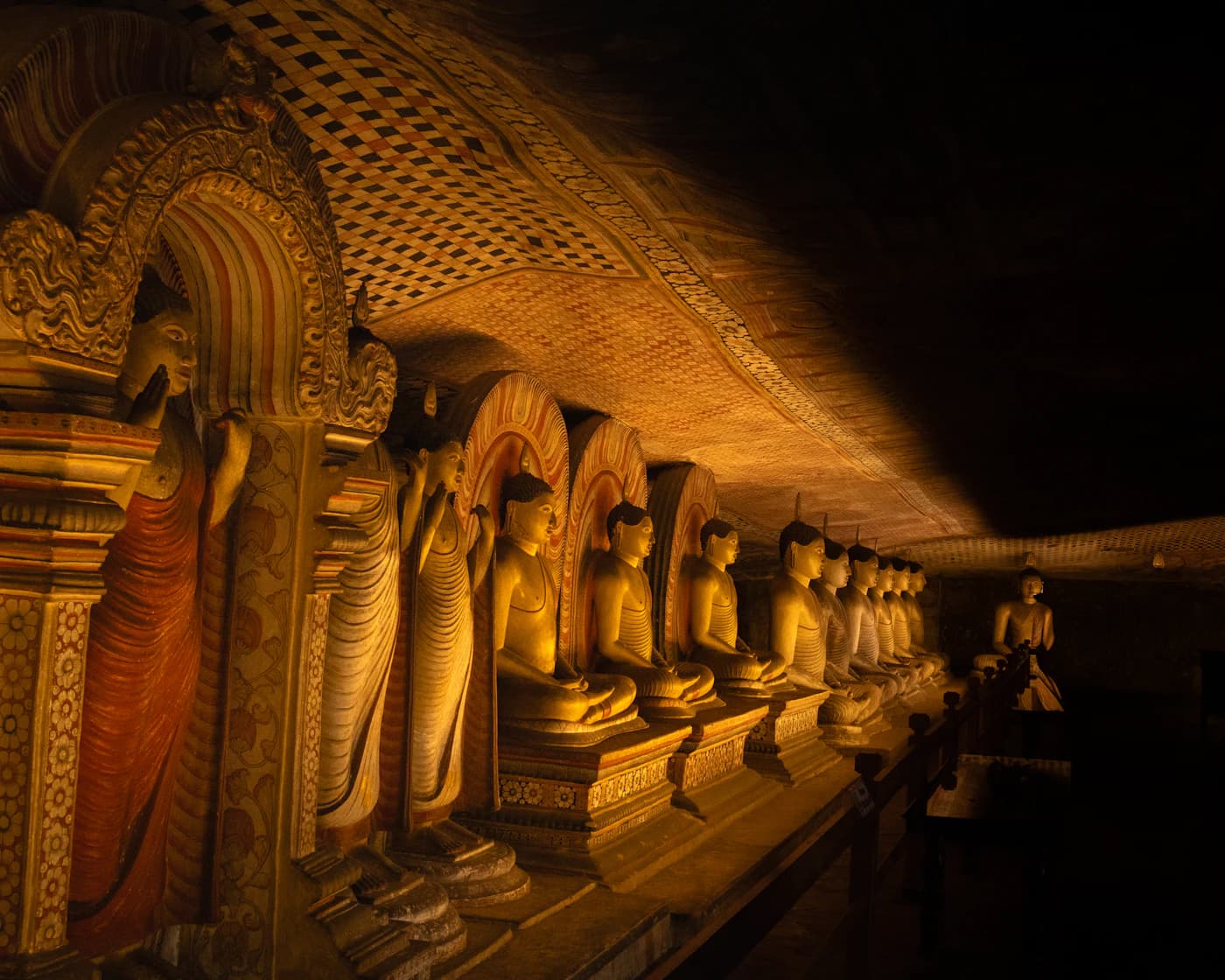 Rows of golden Buddha statues inside Dambulla Cave Temple